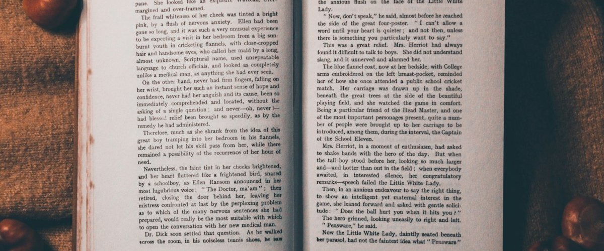 Two open pages of a printed book lying face up, dense with text